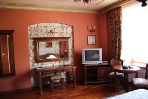 a living room with a stone fireplace and a television at Hotel Staromiejski in Krasnystaw