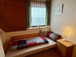 a bed sitting in a room with a window at Ferienwohnungen Kremser bei Spiegelau Eppenschlag in Eppenschlag
