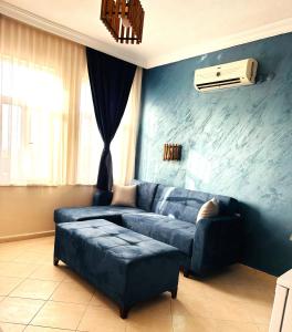 a blue couch in a living room with a fan at pH Ölüdeniz Suite in Fethiye