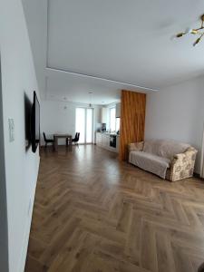 a living room with a couch and a wooden floor at Berryblossom Estate in Krosno