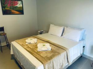 a bedroom with a bed with two towels on it at POUSADA ACONCHEGO CHAPADA in Alto Paraíso de Goiás +70 photos