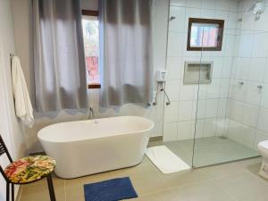 a bathroom with a bath tub and a shower at POUSADA ACONCHEGO CHAPADA in Alto Paraíso de Goiás