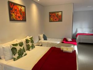 a hotel room with two beds and a couch at POUSADA ACONCHEGO CHAPADA in Alto Paraíso de Goiás