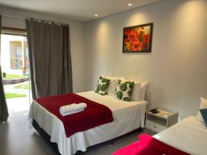 a bedroom with a bed with a red blanket at POUSADA ACONCHEGO CHAPADA in Alto Paraíso de Goiás