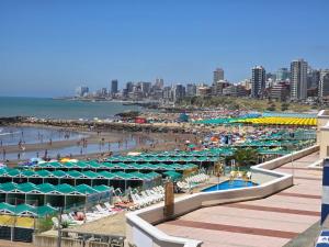 a beach with umbrellas and a crowd of people at La Perla Mar y Sol in Mar del Plata