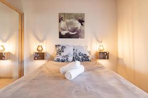 a bedroom with a large bed with two pillows at L'Oasis de SaBen - Piscine Privée in Belfort-du-Quercy +13 photos