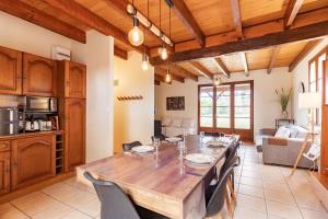 a kitchen and dining room with a large wooden table at L'Oasis de SaBen - Piscine Privée in Belfort-du-Quercy