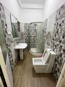 a bathroom with a toilet and a sink at BeachBay Guest House in Negombo