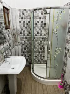 a bathroom with a shower and a sink at BeachBay Guest House in Negombo