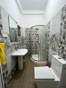a bathroom with a shower and a toilet and a sink at BeachBay Guest House in Negombo