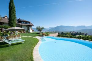 a swimming pool in the yard of a house at Wolkanhof Vineyard Apartments in Appiano sulla Strada del Vino