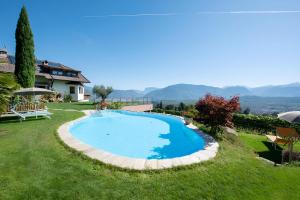 a swimming pool in the yard of a house at Wolkanhof Vineyard Apartments in Appiano sulla Strada del Vino