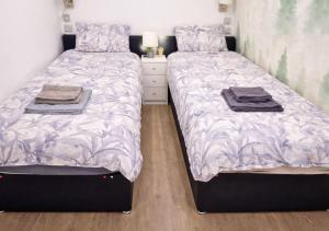 two beds sitting next to each other in a bedroom at Williamson Suites - Apartment 2 in Liverpool