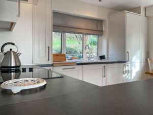 a kitchen with white cabinets and a counter top at Mimosa - Uk51224 in Swyre +11 photos