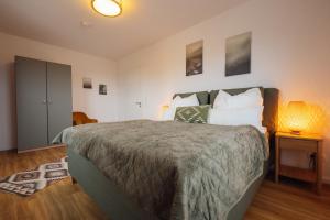 a bedroom with a large bed and a table with a lamp at Penthouse `Wolke 7` am See mit Sauna in Lembruch