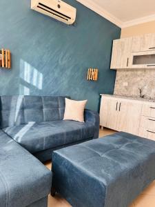 a living room with a blue couch and a table at pH Ölüdeniz Suite in Fethiye +3 photos