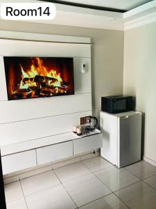 a living room with a fireplace and a tv at The Bright Guest House in Pretoria