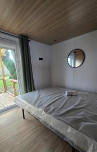 a bed in a room with a large window at Mobil-home Harmonie in Gouvieux