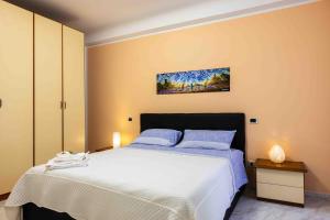 a bedroom with a large white bed with blue pillows at Rio Apartment cà di Euro with parking in Riomaggiore