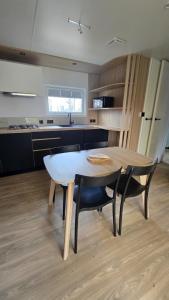 a kitchen with a table and chairs in a room at Mobil-home Harmonie in Gouvieux