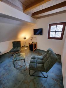 a living room with two chairs and a table at Penzion Vejrovna in Přední Výtoň