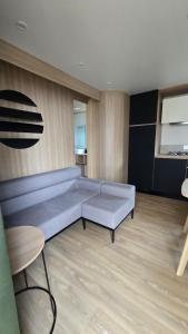 a living room with a large couch and a table at Mobil-home Harmonie in Gouvieux +2 photos