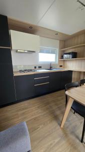 a kitchen with a table and a dining room at Mobil-home Harmonie in Gouvieux