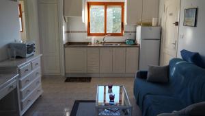 a living room with a blue couch and a kitchen at Albadomus in Denia