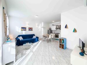 a living room with a blue couch and a kitchen at Rio Apartment cà di Euro with parking in Riomaggiore