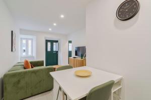 a living room with a table and a clock on the wall at Moradia Bar Sela, By Home Match in Setúbal