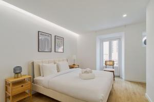 a white bedroom with a large bed with a teddy bear on it at Moradia Bar Sela, By Home Match in Setúbal