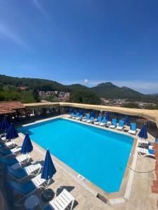 a large swimming pool with lounge chairs and umbrellas at pH Ölüdeniz Suite in Fethiye