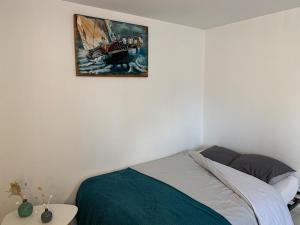 a bedroom with a bed and a painting on the wall at Le Studio du centre - 2-4p - 80 m de la plage in Les Sables-d'Olonne