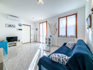 a living room with a blue couch and a tv at Rio Apartment cà di Euro with parking in Riomaggiore