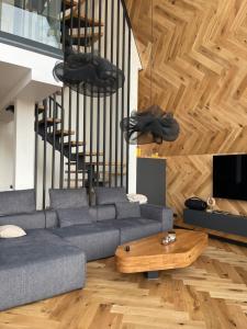 a living room with a couch and a wooden table at TwoTop-Premium Chalet Villa with mountain view in Piatra Fantanele