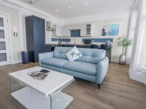 a living room with a blue couch and a table at Vista Mare 1 in Weymouth