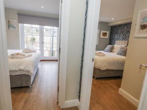 a bedroom with two beds and a mirror at Vista Mare 1 in Weymouth