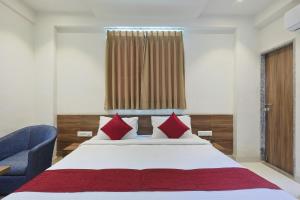 a bedroom with a large bed and a blue chair at The Castle Crown - Hotel Scintilla, Somnath in Somnath