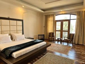 a bedroom with a large bed and a large window at The Landing Nest - Villa in Srinagar