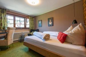 a hotel room with a bed with pillows on it at Landgasthof "Freiämter Hof" in Freiamt +66 photos