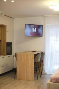 a living room with a table and a tv on the wall at AVA Studio Sinaia in Sinaia