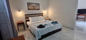 a bedroom with a bed with a hat on it at La Maison de Christine -Adults Only in Chrysi Ammoudia