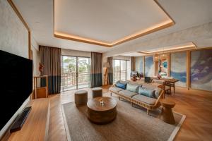 a living room with a couch and a table at Mövenpick Resort & Spa Bintan Lagoon in Lagoi