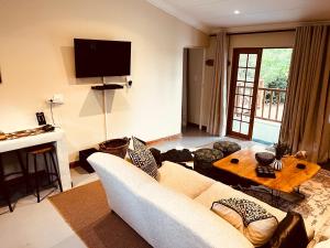 a living room with a couch and a table at Haze Inn Cottages Wattle in Henburg Park