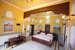 a bedroom with a king sized bed and ornate ceilings at Haveli Kesar Vilas in Chāran ki Dhāni +28 photos