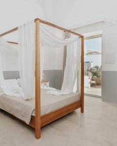 a canopy bed with white curtains in a room at Corte Vespro in Ugento