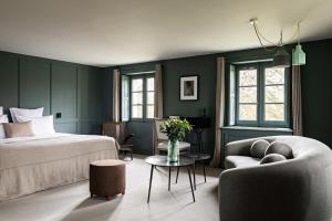 ein Schlafzimmer mit grünen Wänden, einem Bett und einer Couch in der Unterkunft Domaine de Primard - Fontenille Collection in Guainville + 73 Fotos