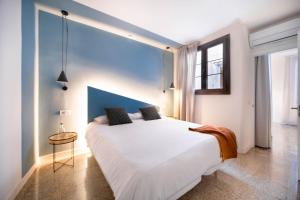 a bedroom with a large white bed with a blue wall at Apuntadores 8 in Palma de Mallorca