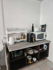 a kitchen with a microwave on a wooden shelf at Escape Root in Caledon