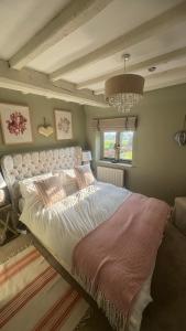 a bedroom with a large bed and a chandelier at Spenford House 1640 listed house Idilic Location pub walking distance in Shrewsbury